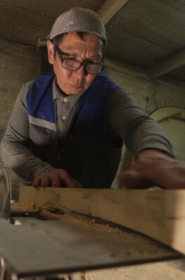 A Mongolian carpenter works on yurt framing.